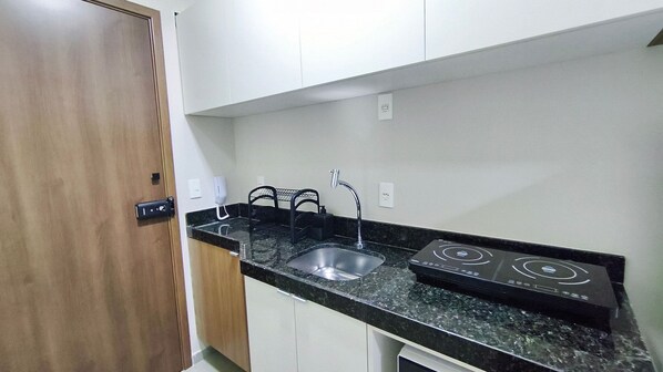 A compact kitchen with a sink, a stove, and a door. - Ora Beach (Ipojuca)