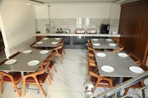 A modern kitchen with a central island, multiple seating arrangements, and a coffee machine.