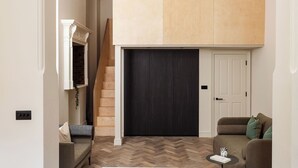 A compact living space with a loft area, a staircase, and a sofa. - FiveM West Hampstead - South (London)