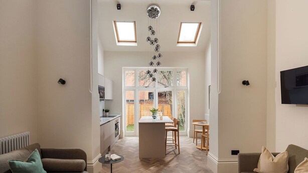A spacious living area with a herringbone floor, a central island, and a dining table with chairs. - FiveM West Hampstead - South (London)