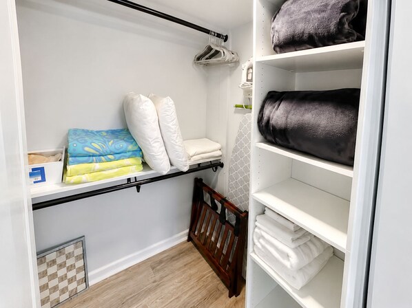 Un dressing avec des étagères, une tringle et un berceau en bois.