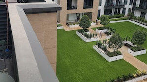 A modern building with multiple floors, outdoor seating areas, and a well-maintained courtyard with greenery. - PREMIUM SUITE (Accra)
