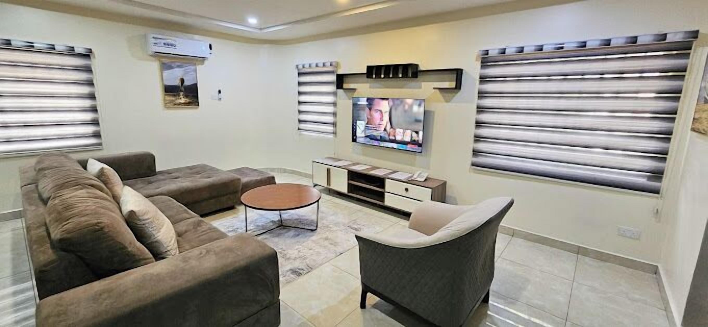 A living room with a sofa set, a coffee table, a TV, and a fireplace.