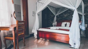Une chambre à coucher avec un lit en bois, un baldaquin blanc et une couvre-lit à carreaux rouges et noirs.