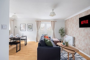 Relax in this stylish living room with a sofa, coffee table, and dining area, perfect for social gatherings and entertainment.