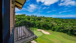 Ein Balkon mit Blick auf einen Golfplatz und umliegendes Grün.