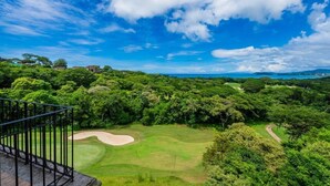 Ein Golfplatz mit freiem Blick auf den umliegenden Wald und ferne Hügel.