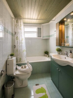 Ein Badezimmer mit Toilette, Badewanne, Waschbecken und Spiegel.