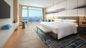 A modern hotel room with a large bed, a desk, and a view of the city. - Courtyard By Marriott Guangzhou Pazhou (Guangzhou)