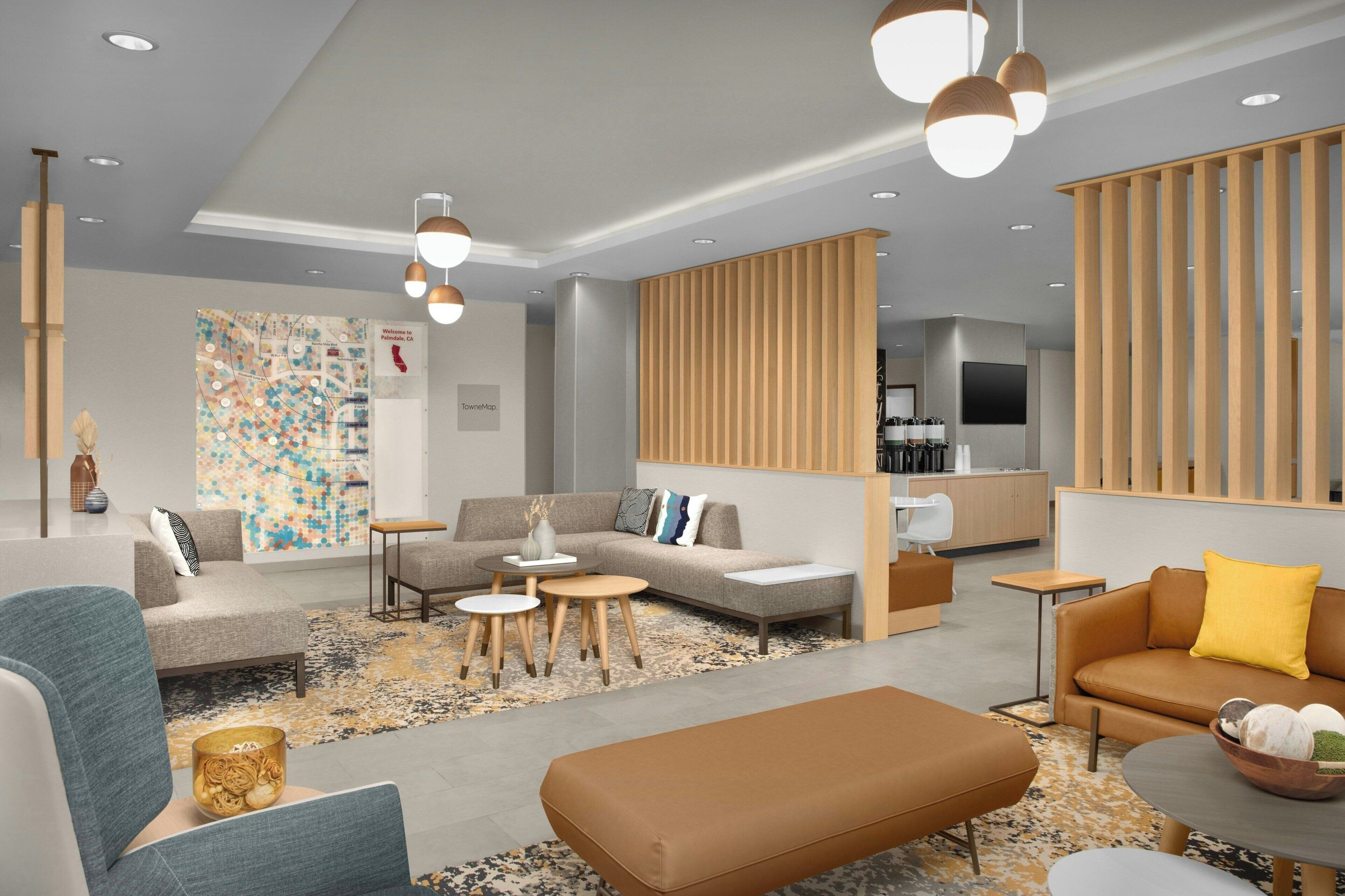 A modern living room with a sofa, ottoman, coffee table, and a TV area with a wooden partition.