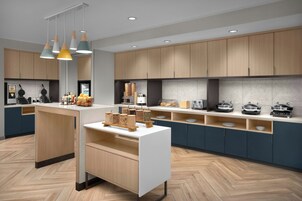 Una cucina moderna con mobili in legno, un'isola centrale e diversi elettrodomestici.