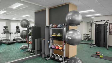 A gym with treadmills, exercise balls, and weightlifting equipment.