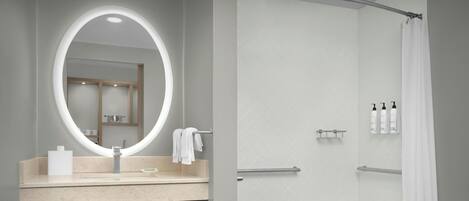 A modern bathroom with a vanity, a mirror, a bathtub, and a shower curtain.