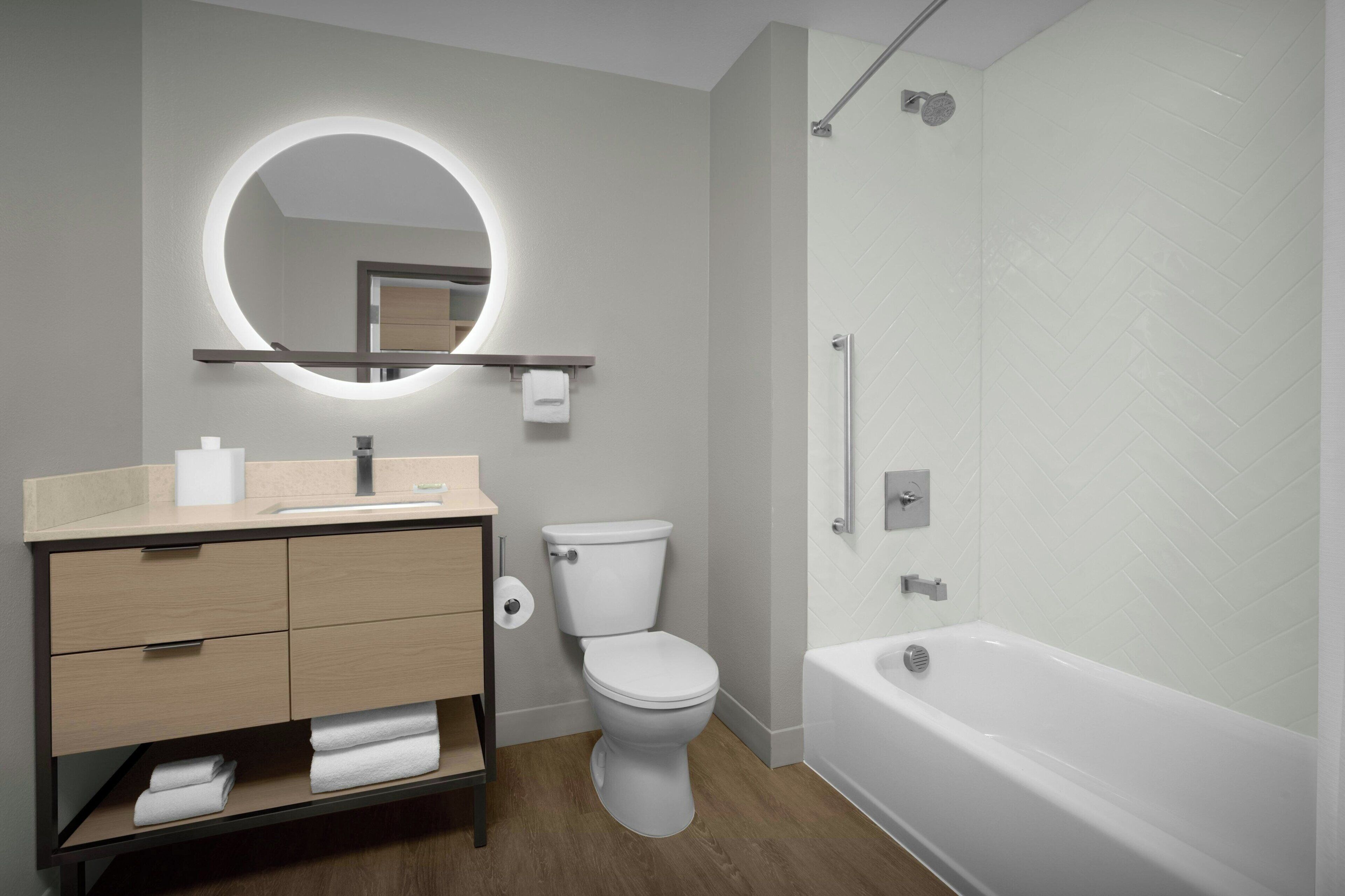 Un baño moderno con inodoro, lavamanos, tocador y bañera.
