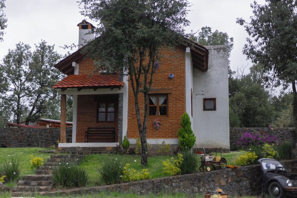 A house with a brick facade, a wooden porch, and a stone wall. - Finca la Patrona By GEstores (Huasca de Ocampo)