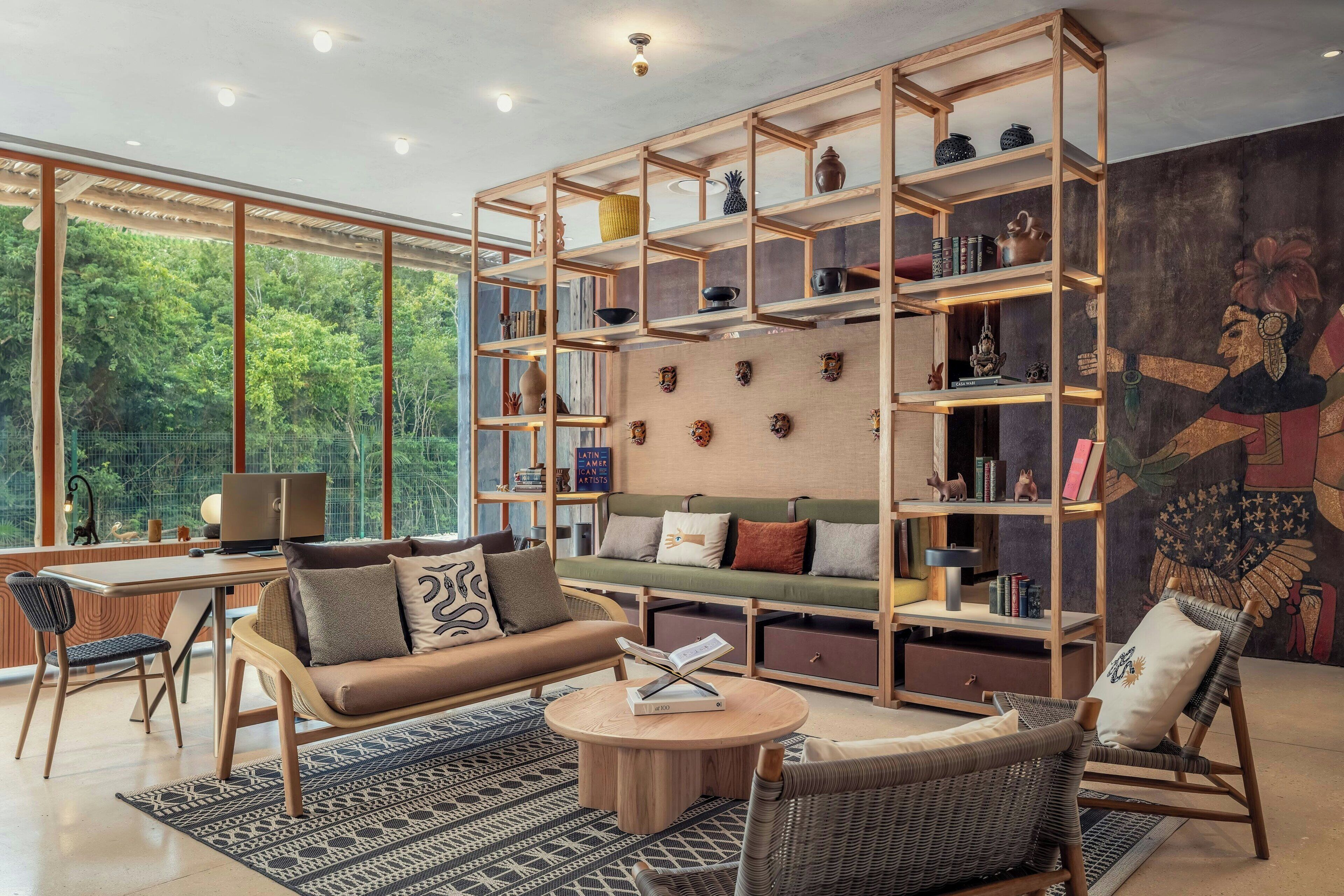 Una sala de estar moderna con una estantería de madera, un sofá, una mesa de centro y un mural en la pared.