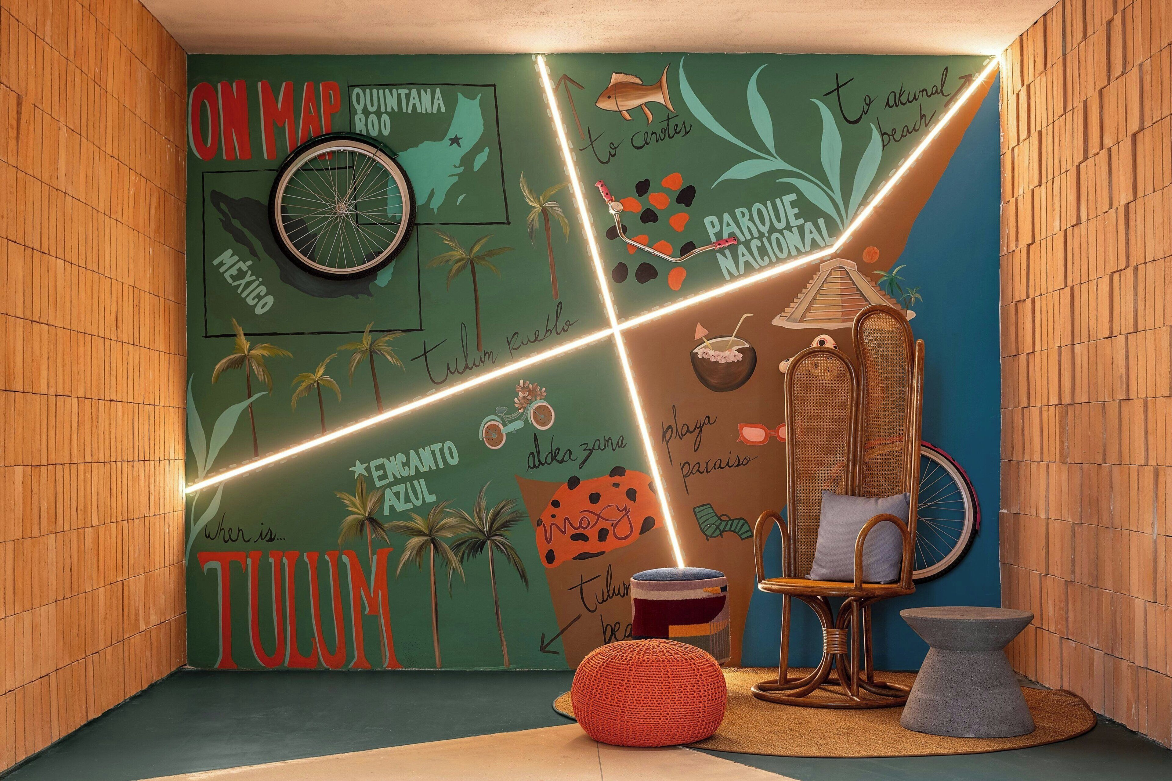 Una habitación con un mural que muestra un mapa, una bicicleta y elementos tropicales.