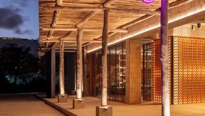 Un bâtiment avec un toit de chaume et un panneau lumineux au néon qui affiche le mot « mozy ».