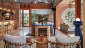 Un intérieur moderne comprenant un espace salon central, un coin repas et une grande fenêtre offrant une vue dégagée.