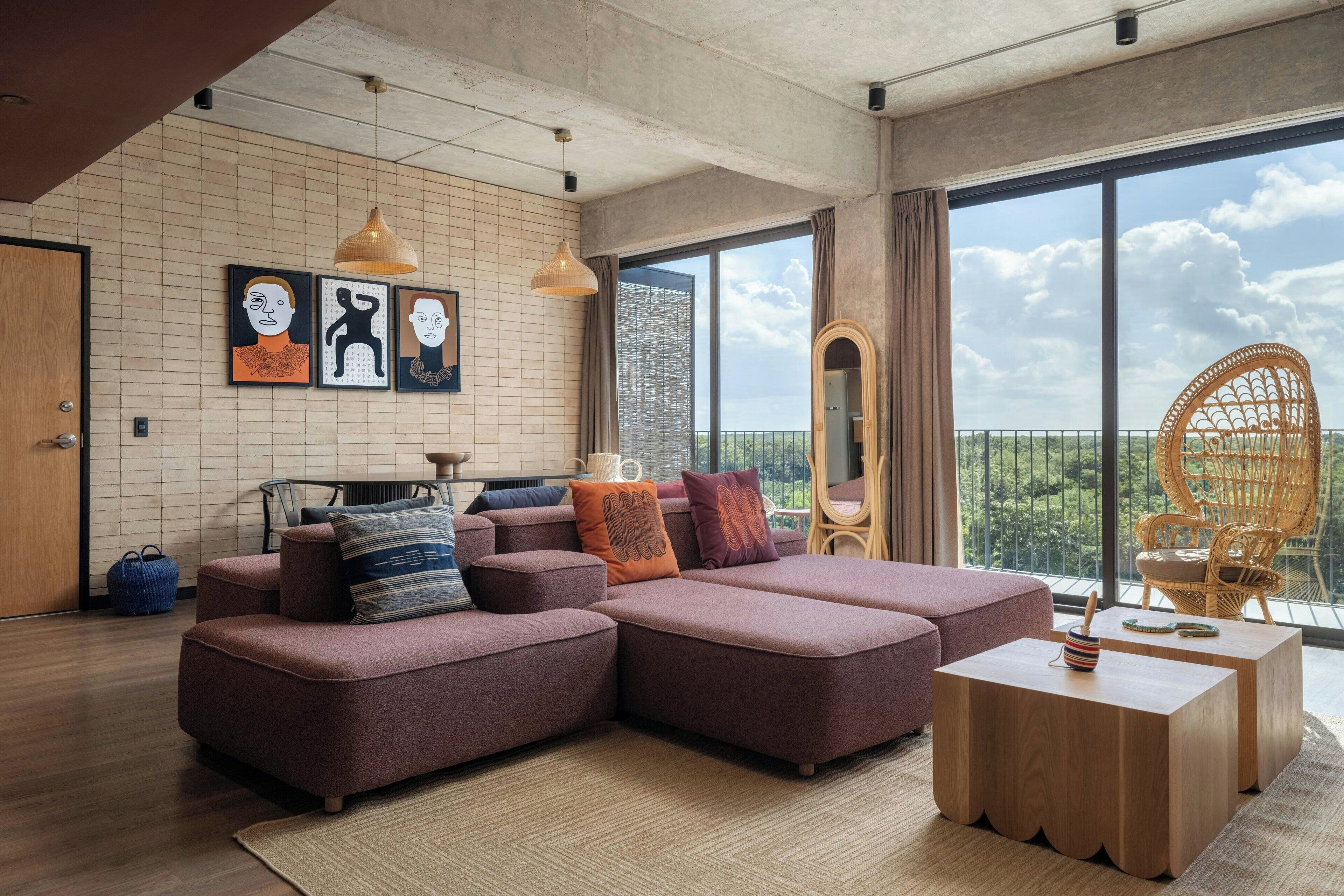 A modern living room with a sectional sofa, a wooden coffee table, and a large window with a view of greenery.