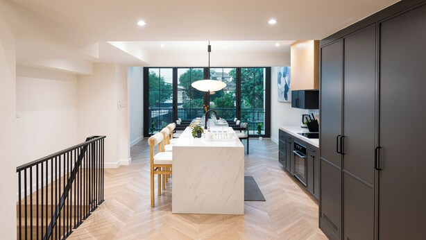 A modern kitchen with a central island, large windows, and a view of the outdoors. - Luxury 5BR Poolhouse & Theater - 2mins to BTS (Bangkok)