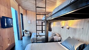A wooden interior with bunk beds, a ladder, a flat-screen TV, and a chair. - Olas de Buchupureo - con vida de campo (Buchupureo)