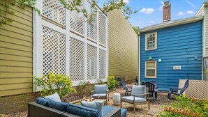 A patio with wicker furniture and a white lattice screen.
