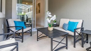 An outdoor seating area with a sofa, two chairs, and a table. - FL- 1042 Splash Shot (Davenport)