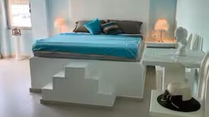 A modern bedroom with a bed, bedside tables, and a chair.