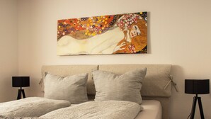 A bedroom with a bed, two bedside tables, and a painting on the wall. - Idyllic vacation apartment 300m from the Zwischenahner Meer (Bad Zwischenahn)