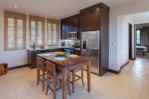 Una cocina moderna con armarios de madera oscura, electrodomésticos de acero inoxidable y una isla central con asientos.