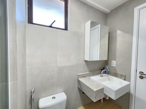 Ein Badezimmer mit Toilette, Waschbecken und Spiegel.