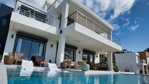 A modern two-story building with a pool, outdoor seating, and a balcony. - AZUR -  NEW SEA SIDE DR, 4 BR, 4.5 BA -  WALK TO  INDIGO BEACH (Sint Maarten)