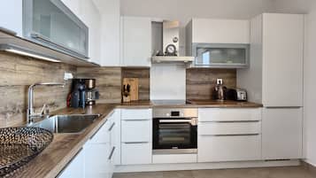 Deluxe Apartment, Beach View | Private kitchen | High chair