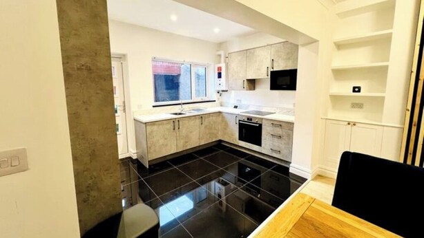 A modern kitchen with black tiled flooring, white cabinetry, and a built-in microwave. - Modern 2-bed house  in Blyth centre  with two bedrooms and two bathrooms (Blyth)