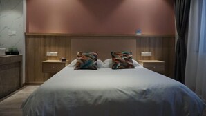 A hotel room with a bed, two bedside tables, a nightstand, a wooden headboard, and a marble wall. - Biligong Hotel Shanghai (Shanghai)