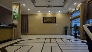 A hotel lobby with a reception desk, a chandelier, a framed artwork on the wall, and a patterned floor. - Biligong Hotel Shanghai (Shanghai)