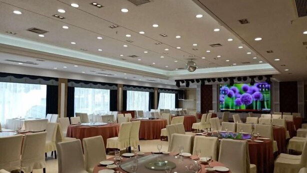 A conference room with multiple tables set for dining, equipped with chairs and dining essentials. - Biligong Hotel Shanghai (Shanghai)