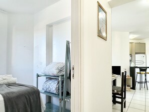 Habitación pequeña con literas, escritorio y silla.