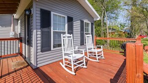 A small cabin with a deck, two rocking chairs, and a covered porch area.