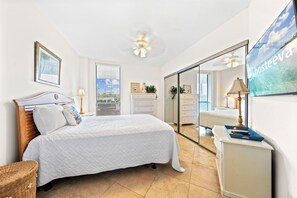 A bedroom with a bed, a dresser, a mirror, and a ceiling fan. - Windward Pointe 104 with Beach Access (Orange Beach)