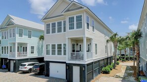 A two-story residential building with a balcony, a garage, and a driveway. - 6 10th Avenue by Avantstay Steps to the Beach Pool 2691 Sqft (Isle of Palms)