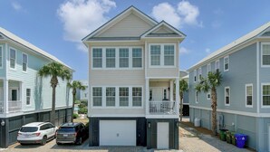 A two-story residential building with a garage, a balcony, and a driveway with parked cars. - 6 10th Avenue by Avantstay Steps to the Beach Pool 2691 Sqft (Isle of Palms)