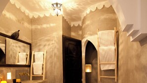A bathroom with a freestanding bathtub, a vanity with a mirror, and a towel rack. - Spacious 5-bedroom riad in charming Marrakesh with AC, WiFi and Pool (Marrakesh)