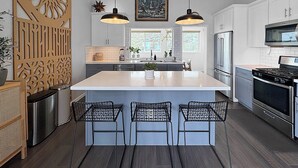 A modern kitchen with a large island, pendant lights, and a built-in oven. - Mountain Top 4 Bdrm Home Along Nature Reserve with Spectacular Views, AC & WiFi (Spring Valley)