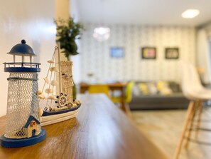 A model ship with a lighthouse and a sailboat on a wooden table. - Resid. Clube Mar Grosso-Laguna - LAG208 (Laguna)