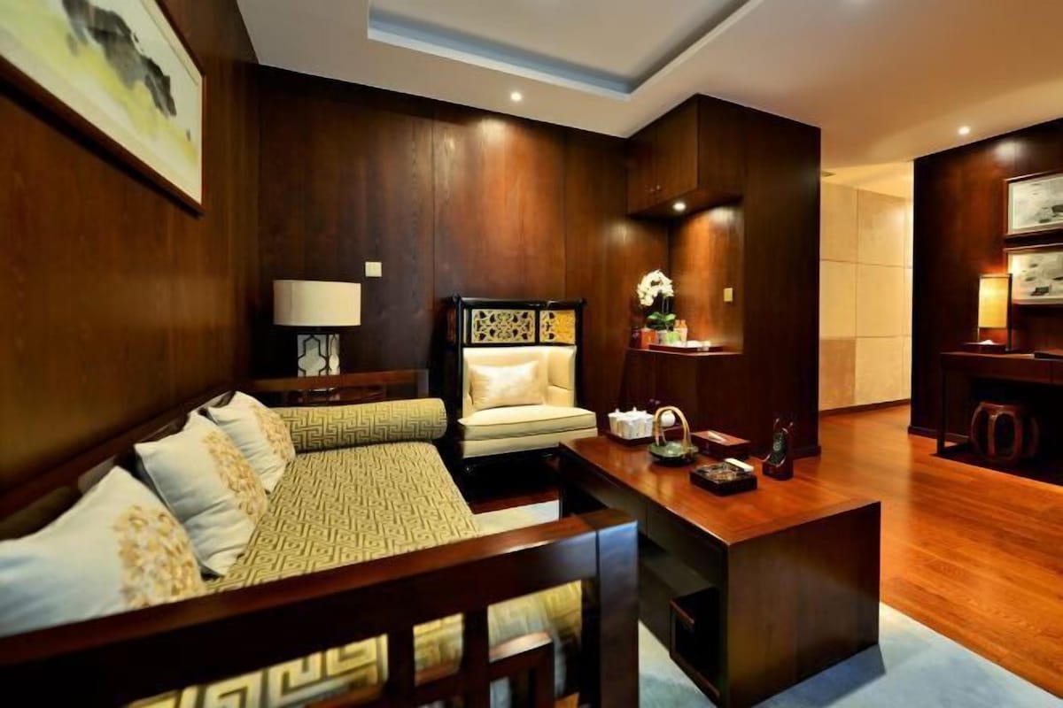 A modern living room with a sofa, armchair, and coffee table.