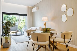 Ein moderner Essbereich mit einem Glastisch, vier Stühlen, einer Schüssel und einer Lampe.