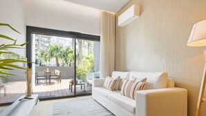A modern living room with a white sofa, a glass door leading to an outdoor patio, and a minimalist design. - Acqua s Bliss by Homie (Funchal)