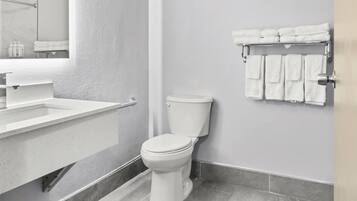 A modern bathroom with a white toilet, a sink, and a towel rack.